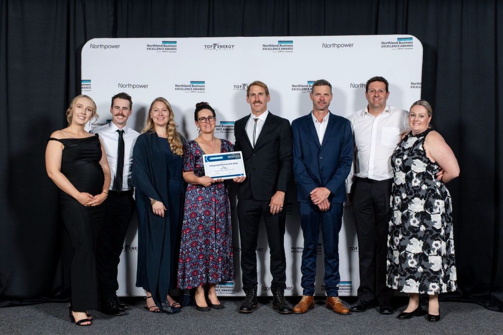 Integrated Electrical & Solar team members and their partners holding the finalist certificate at the 2026 Northland Business Excellence Awards, McKay Stadium, Whangārei